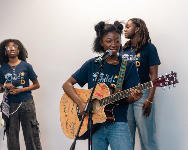 A young worship leader singing and playing guitar